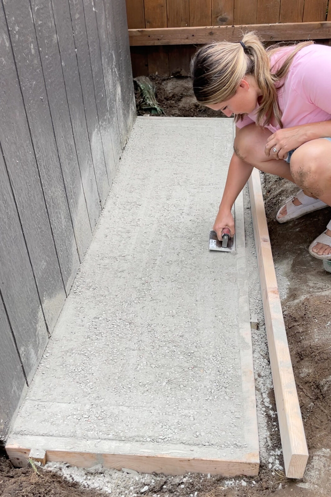 Using a concrete edger tool on a dry pour concrete pad. 